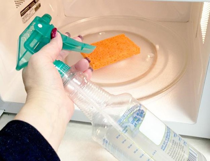 Dùng nước rửa chén hoặc nước lau kính để vệ sinh lò vi sóng